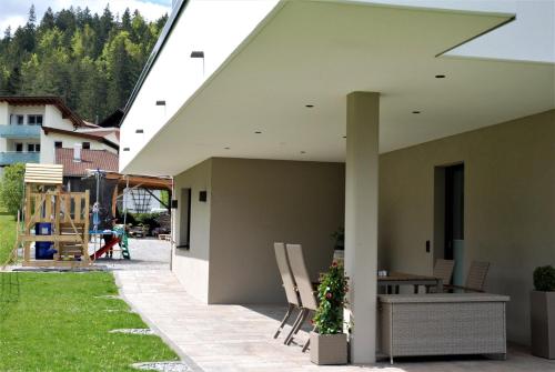 a patio with chairs and a table on a house at fewo kramer in Heiterwang
