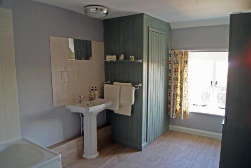a bathroom with a sink and a toilet and a window at The Old Smithy Bed & Breakfast in Clovelly