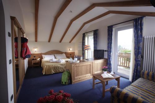 a hotel room with a bed and a window at Hotel Lido - slow & natural living in Molveno