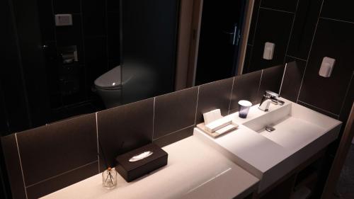 a bathroom with a sink and a mirror at Hotel bridge Seogwipo in Seogwipo