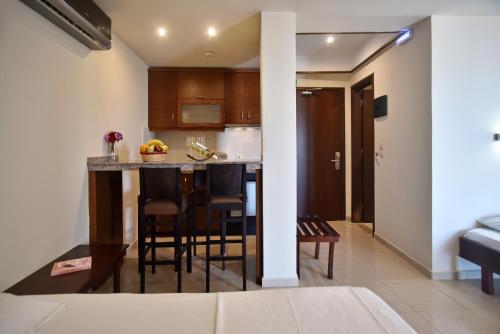 a kitchen and living room with a table and chairs at 24 Seven Boutique Hotel in Malia