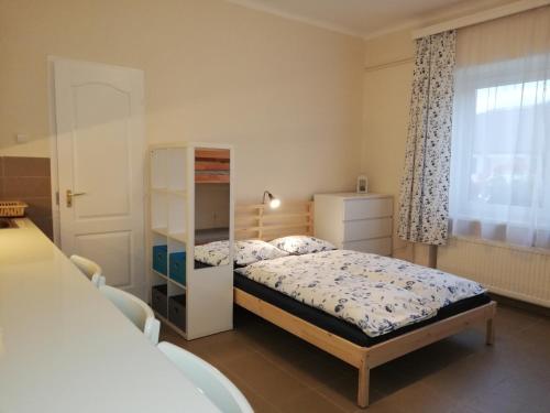 a small bedroom with a bed and a window at Gyöngyszem Vendégház in Eger