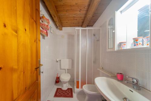 a bathroom with a sink and a toilet and a window at coda cavallo villaggio cala paradiso villino C4 in San Teodoro