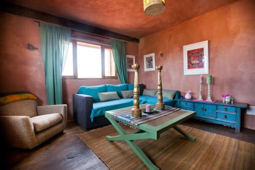 a living room with a blue couch and a table at Hubara Retreat in Charco del Palo