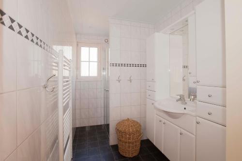 Hezingen的住宿－Bos en Heide，白色的浴室设有水槽和卫生间。