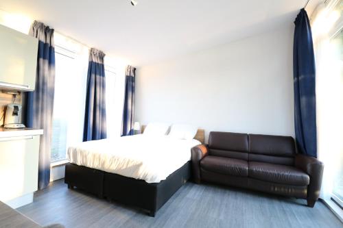 um quarto com uma cama e um sofá de couro em Waegen Uus em Wolphaartsdijk