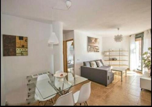 een woonkamer met een glazen tafel en een bank bij Apartamento Zahara de los Atunes-Atlanterra in Zahara de los Atunes