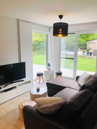 WanzeにあるJuste à Côté, Maison de caractère avec piscineのソファと薄型テレビのあるリビングルーム