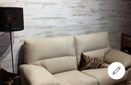 un sofá blanco en una sala de estar con lámpara en JARDINES DE MURILLO, calle Rastro, en Sevilla
