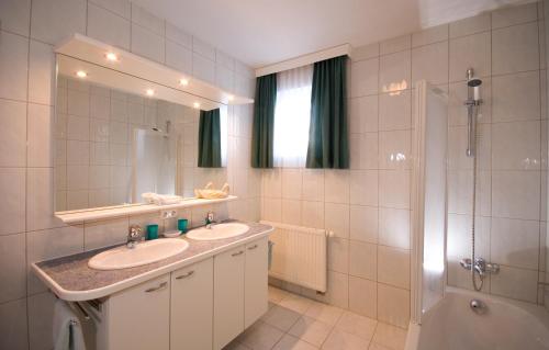 イェルツェンスにあるFerienhaus Lissのバスルーム(洗面台2台、シャワー、鏡付)
