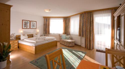 sypialnia z łóżkiem i krzesłem w pokoju w obiekcie Ferienhaus Liss w mieście Jerzens
