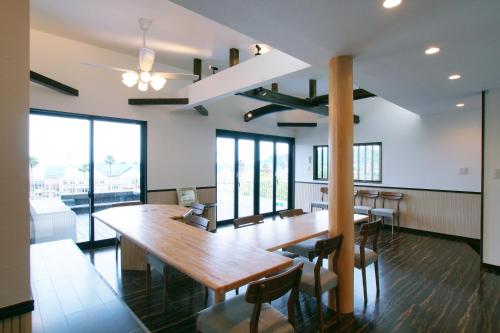 a dining room with a large wooden table and chairs at Famille Yukawa in Ito