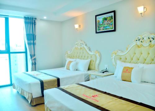 a hotel room with two beds and a window at Phuong Hoang Hotel 2 in Sầm Sơn