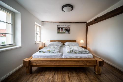 a bedroom with a bed in a room with two windows at Ferienwohnungen Finkenherd 5 in Quedlinburg