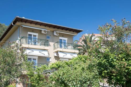 a building with balconies and trees in front of it at Dimitreli Eleni Studios in Koinyra