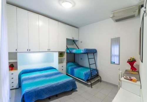 a bedroom with two bunk beds and a ladder at Appartamenti Bianchi in Bibione