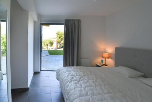 a bedroom with a bed and a sliding glass door at Modern Seaside Villa K2 in Kriopigi