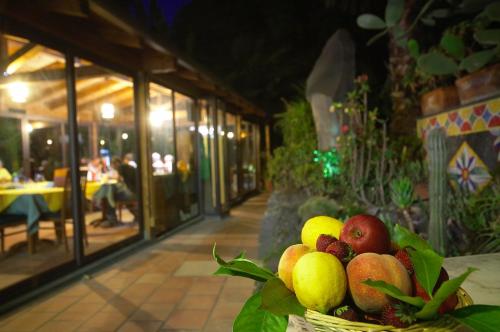 a basket of fruit on a table in a restaurant at Hotel Borgo Verde in Catania