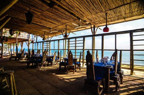 a restaurant with tables and chairs and a view of the ocean at Mediterraneo Boutique Hotel in Dar es Salaam