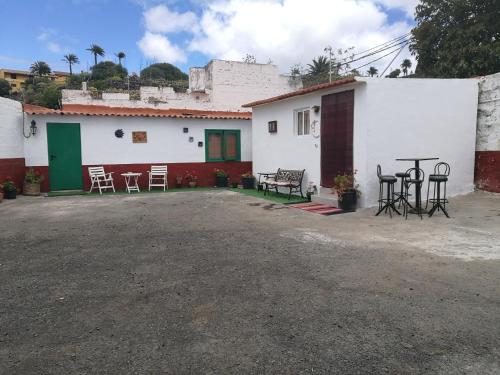 a house with a table and chairs in front of it at Residencia Los Conejos - Bike & Motorbike in Las Palmas de Gran Canaria