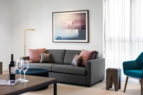 a living room with a gray couch and a table at Quest Burwood East in Burwood