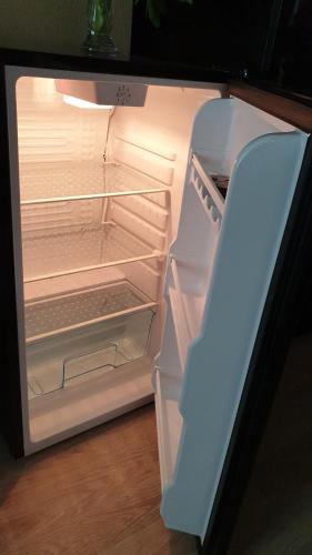 an empty refrigerator with its door open in a kitchen at Rīgas 20/1 apartaments in Cēsis