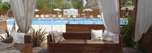 una panchina seduta di fronte alla piscina di Hotel Loretta a Rimini