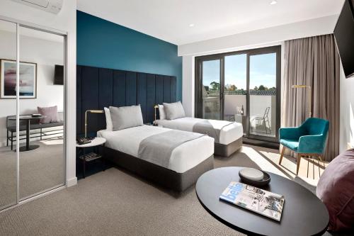 a hotel room with two beds and a table at Quest Burwood East in Burwood