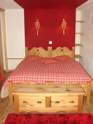 a bedroom with a wooden bed with a red wall at Auberge de la poste in Les Diablerets