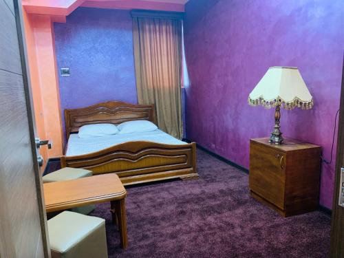 ein Schlafzimmer mit einem Bett, einem Tisch und einer Lampe in der Unterkunft HOTEL N1 in Yerevan