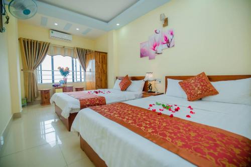 a hotel room with two beds with flowers on them at Cat Ba Bay Vision Hotel in Cat Ba