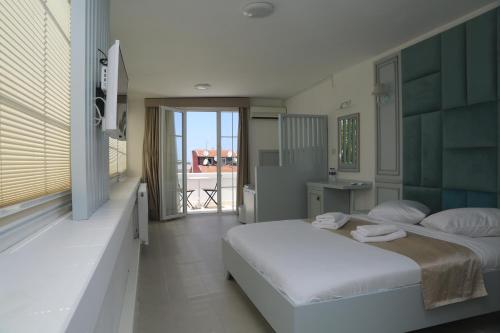 a bedroom with a large bed and a balcony at Buyukada Cankaya Hotel in Buyukada