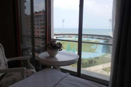 a room with a table and a window with a view of a pool at Hanzade Park Hotel in Trabzon