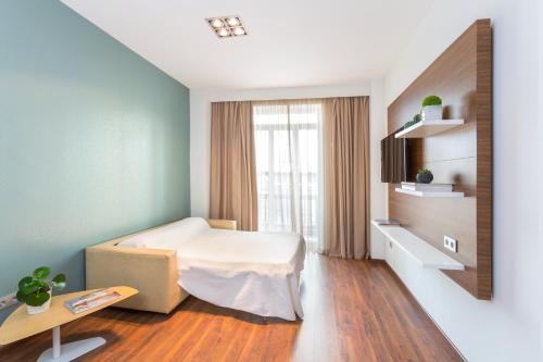 1 dormitorio con cama, mesa y ventana en Center City Flats, en Valencia