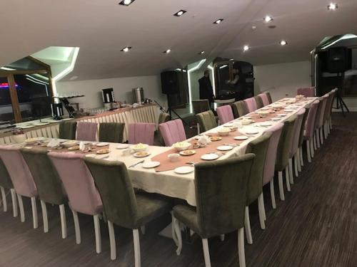 a long table in a room with pink chairs at Hanzade Park Hotel in Trabzon