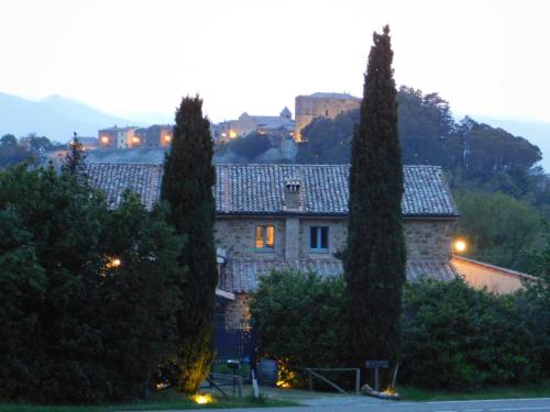 a large stone house with trees in front of it at Podere Orto Wine Country House in Trevinano