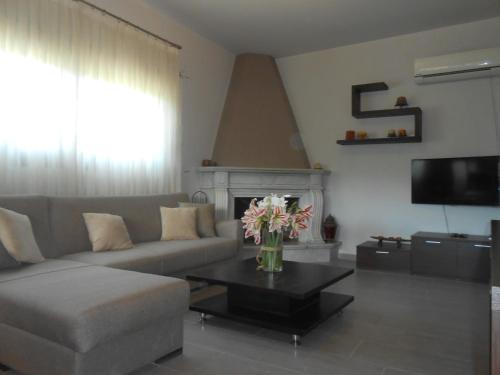 a living room with a couch and a table with flowers at Villeta Nikol in Lixouri