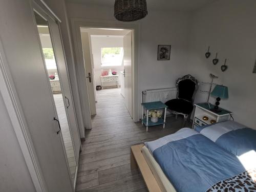 a bedroom with a bed and a hallway with a chair at Wohnung am Stadtwald in Krefeld