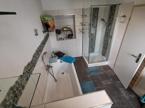 a small bathroom with a shower and a tub at Wohnung am Stadtwald in Krefeld