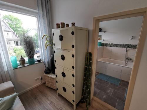 een badkamer met een witte kast en een bad bij Wohnung am Stadtwald in Krefeld