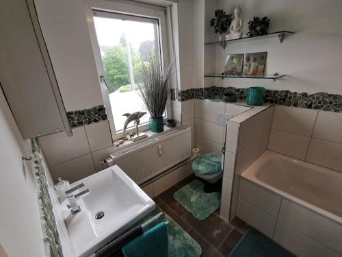 a bathroom with a sink and a toilet and a window at Wohnung am Stadtwald in Krefeld