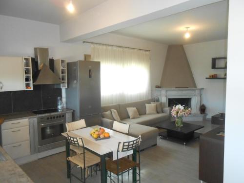 a kitchen and living room with a couch and a table at Villeta Nikol in Lixouri