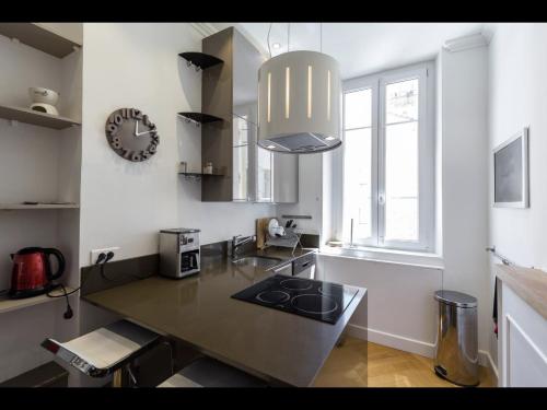 une cuisine avec une table et une horloge au mur dans l'établissement central CANNES - Luxury Clara Residence, à Cannes