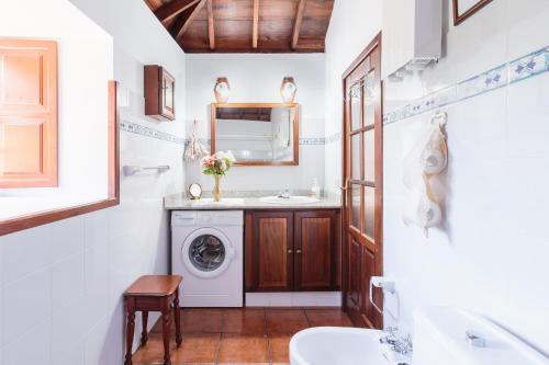 ein Badezimmer mit Waschmaschine und Waschbecken in der Unterkunft El Sitio La Rosa in Mazo