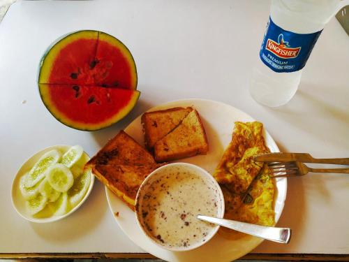 a plate of breakfast food with a bowl of cereal and a cup of coffee at Havelock Farms Resort in Havelock Island