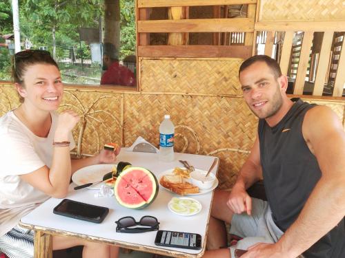 a man and woman sitting at a table with a plate of food at Havelock Farms Resort in Havelock Island