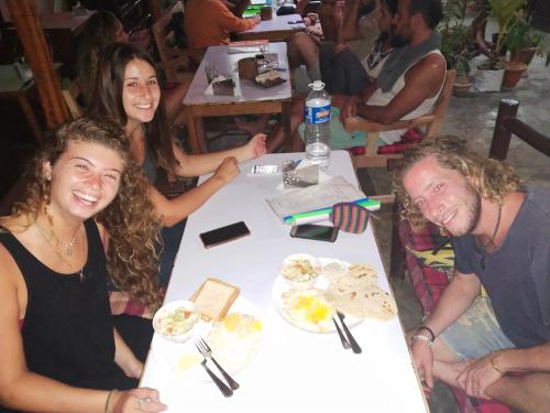 a group of people sitting at a table with food at Havelock Farms Resort in Havelock Island