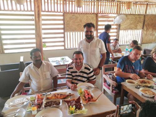 a group of men sitting at a table eating food at Havelock Farms Resort in Havelock Island