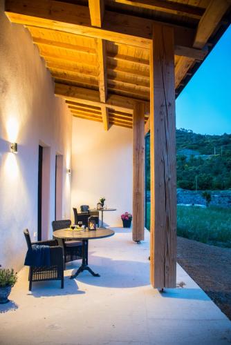 un patio avec une table et des chaises sous une pergola en bois dans l'établissement villa d'illouvre, à Saint-Chinian