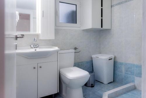 a white bathroom with a toilet and a sink at Pnyka Apartment 2 in Athens